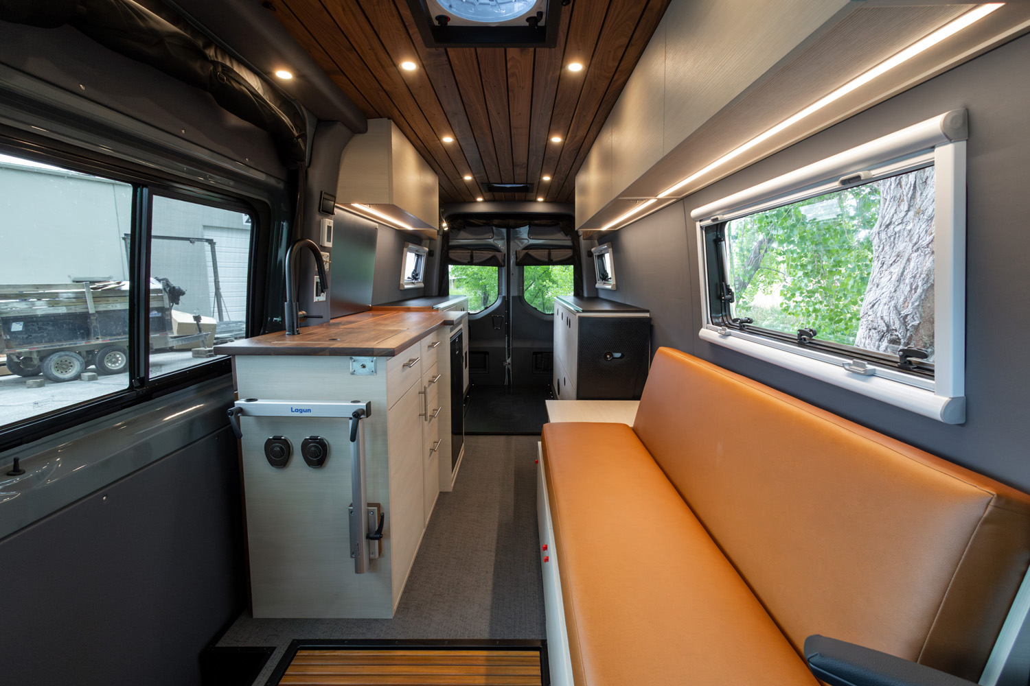 SAGA Vans Sprinter 170 interior with futon and full galley with modular bed and hardwood ceiling
